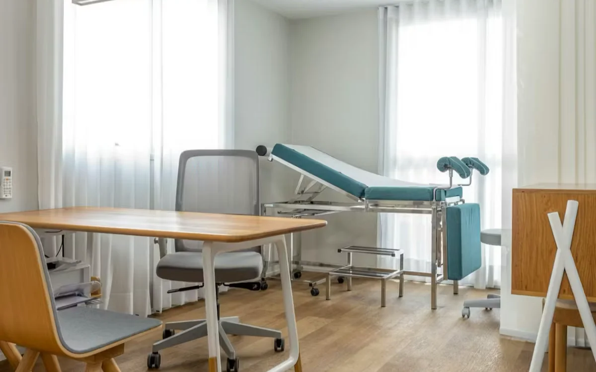 Sala de exame com maca e mesa de atendimento
